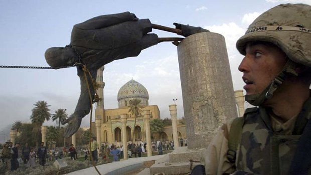 Symbolic fall: A US marine watches the April 2003 toppling of Saddam Hussein's statue in Baghdad.
