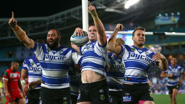 Happy Dogs: Sam Kasiano, Tim Browne and Josh Reynolds celebrate Browne's try.