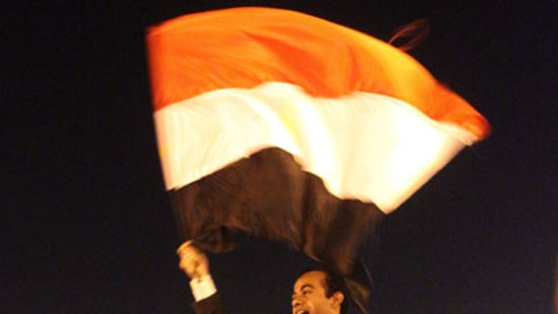 Flying the flag for change ... Abdullah al-Qadi waves the Egyptian flag while being carried by anti-government demonstrators during celebrations of his wedding to Sonia al-Beali in Tahrir Square in Cairo.