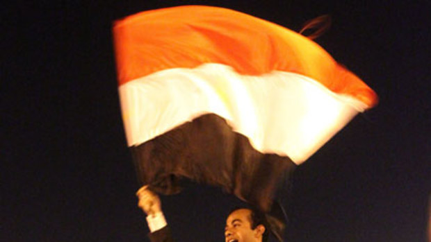 Flying the flag for change ... Abdullah al-Qadi waves the Egyptian flag while being carried by anti-government demonstrators during celebrations of his wedding to Sonia al-Beali in Tahrir Square in Cairo.