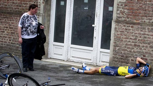 A spectator considers Jonathan Cantwell after he crashed during the fifth stage of the 2012 Tour de France bewteen Rouen and Saint-Quentin, France.