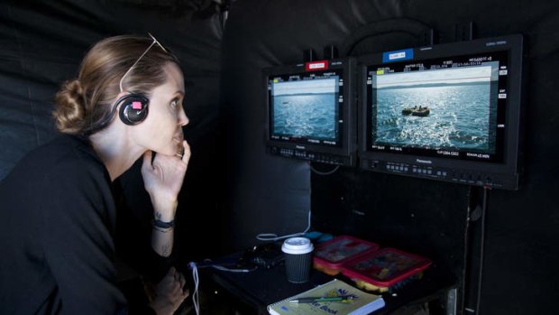 Angelina Jolie looks at footage of epic survival movie 'Unbroken' on set.