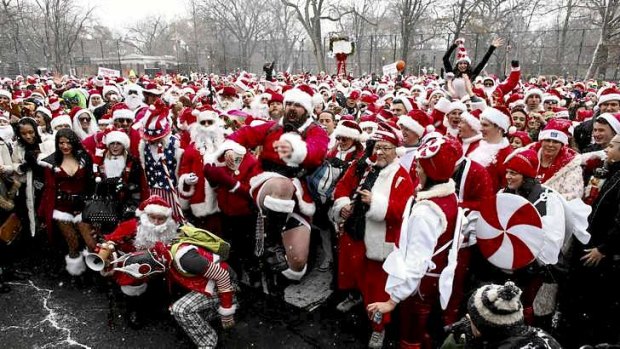 Revelers dressed as Santa Claus pose for a picture at a park during the SantaCon event in New York December 14, 2013. Pub crawlers dressed like Santa Claus took part in New York's annual SantaCon. The revelers wore Santa suits or red minidresses with white trim and nearly all had Kris Kringle hats topped with a white pom-pom.