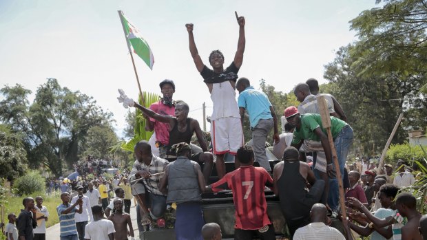 Demonstrators climb aboard a military truck as they celebrate what they perceive to be an attempted military coup d'etat, with army soldiers riding in an armoured vehicle in the capital Bujumbura, Burundi.