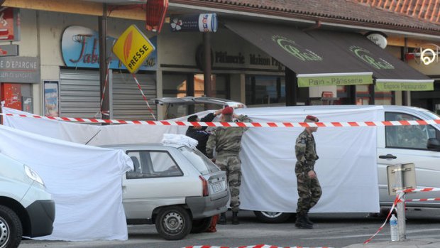 French soldiers stand guard on the site where three soldiers were killed in a drive-by shooting.