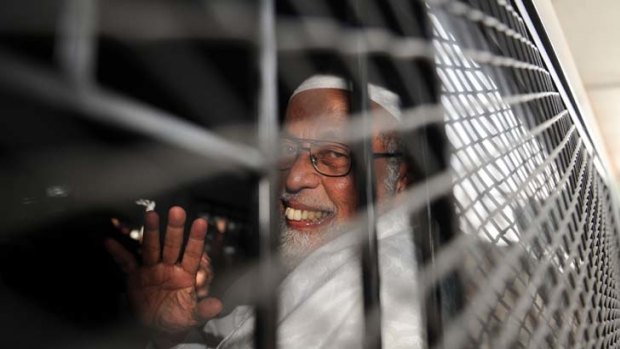 Hard cell ... Abu Bakar Bashir waves after being sent to jail.