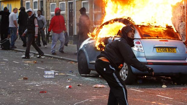 A rioter throws a rock at riot police in Clarence Road in Hackney.