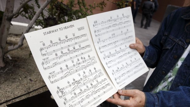 A Led Zeppelin fan holds up sheet music for <i>Stairway to Heaven</i> outside of federal court in Los Angeles.
