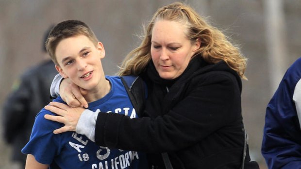 Sandy Gasper clutches son Doug, a ninth grader at Chardon High, after today's shooting.