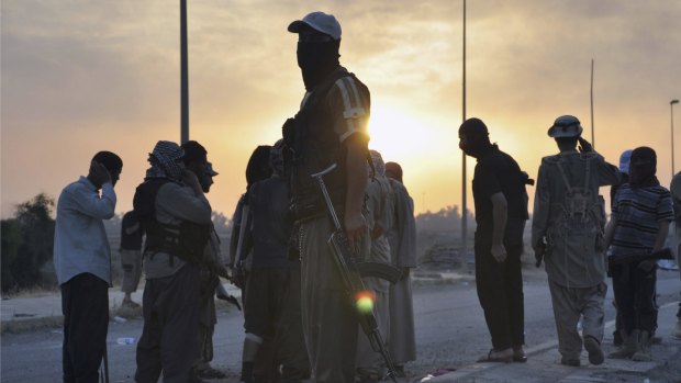 Islamic State fighters stand guard at a checkpoint in the northern Iraq city of Mosul.