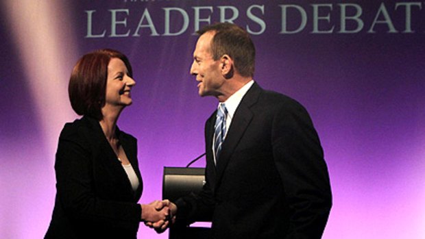 Let the battle begin: Julia Gillard and Tony Abbott shake hands before the debate last night.