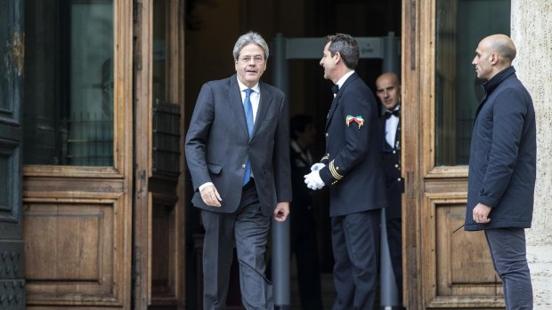 Paolo Gentiloni, left, leaves the Italian lower Chamber in Rome.
