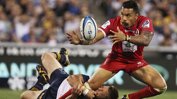 Digby Ioane of the Reds is tackled by Clyde Rathbone of the Brumbies.