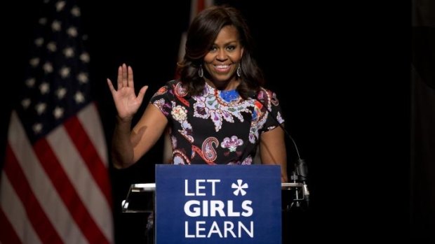 US first lady Michelle Obama waves as she receives a rock star reception by school girls at Mulberry School for Girls before taking part in a question and answer session in east London.