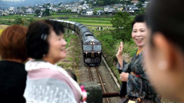 Passengers pose above the Nanatsuboshi, or Seven Stars, sleeper train