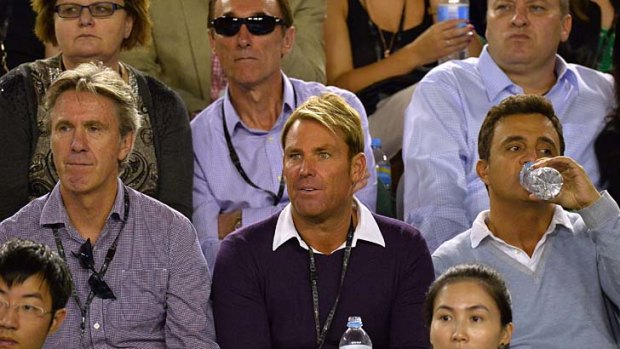 Warne (C) watches Rafael Nadal play Roger Federer at the 2014 Australian Open.