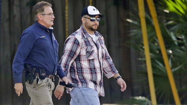 George Zimmerman, right, is escorted by a police officer after a domestic incident was reported.