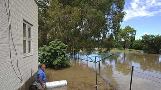 Canberra resident Greg Hill watches flood waters at his weekend home at Jugiong.