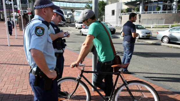 On patrol ... officers speak to an unhelmeted cyclist near Pyrmont Bridge, Sydney.
