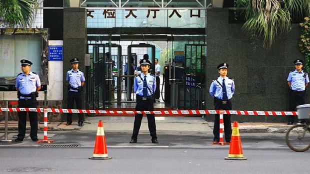 Police officers stand outside court for the trial of Chongqing's police chief Wang Lijun.