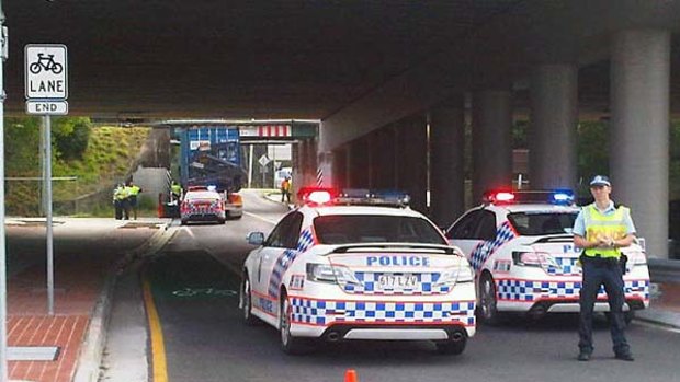 A semi-trailer sits wedged underneath the Ipswich Motorway at Goodna.