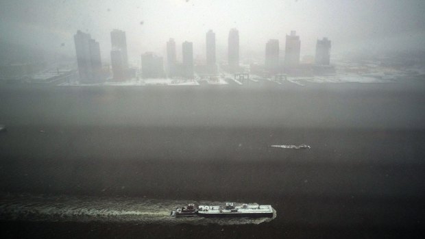 A tugboat sails on the East River during a snow storm in New York on Monday.