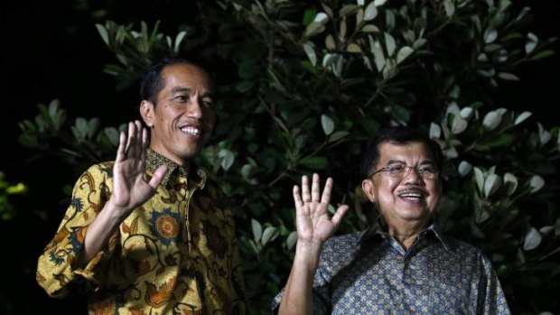Indonesian president-elect Joko Widodo (left) and his running mate Jusuf Kalla wave to the media at a press briefing in Jakarta.