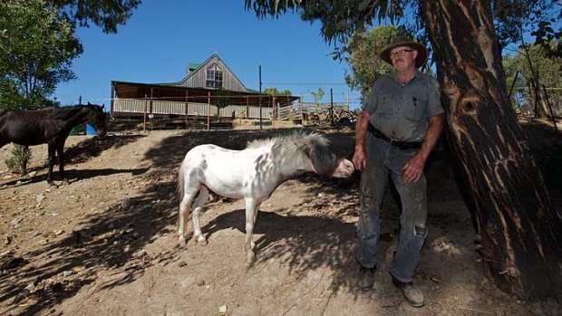 Tony Laurie outside his new home in Clonbinane, where the scars from Black Saturday are still visible on the vegetation.