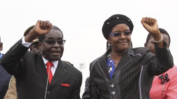 Zimbabwean President Robert Mugabe and his wife Grace wave to supporters and guests during celebrations to mark his 90th birthday.