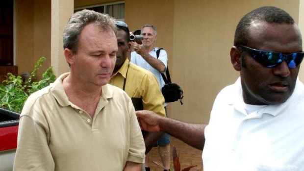 Conman Peter Foster is led back into custody by Correctional Services staff after his court hearing in the Vanuatu Magistrates' Court.