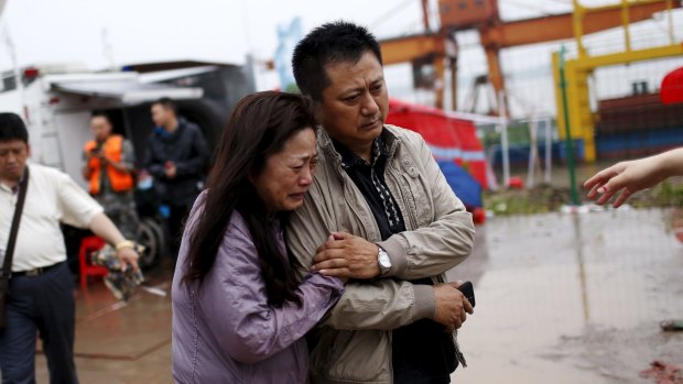 Relatives of a missing passenger aboard a capsized ship cry on the banks of the Jianli section of Yangtze River in Hubei province, China on Thursday. Hundreds of passengers are still missing.