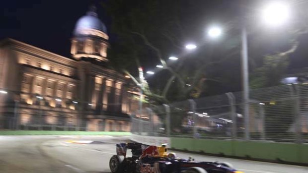 Red Bull driver Mark Webber passes the Supreme Court building during the opening practice session for the Singapore Grand Prix on Friday.