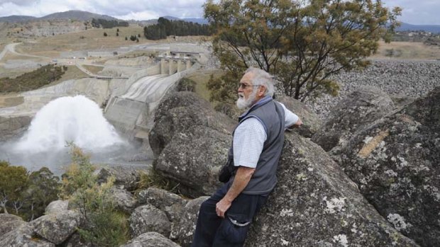 And the water came thundering down ... John Gallard, the chairman of the Snowy River Alliance, watches the water flooding over the Jindabyne Dam spillway, exploding as it hits the river bed yesterday.