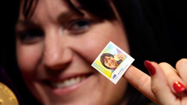 Anna Meares shows off a stamp with her face on it.