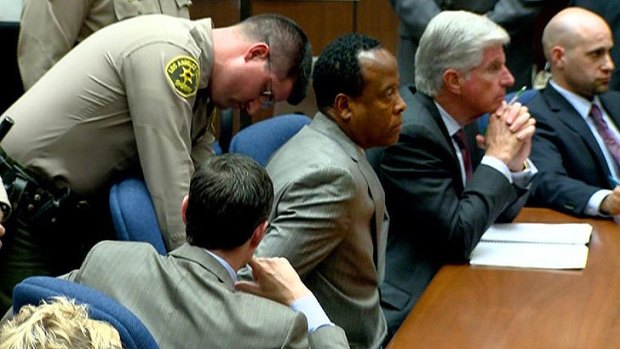 Cuffed ... a sherriff puts handcufffs on Dr Conrad Murray in court after the verdict is announced.