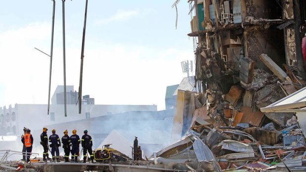 Stunned &#8230; rescuers stand at the smoking ruins of the Canterbury Television building in Christchurch in February 2011. A total of 115 people were killed when it collapsed.
