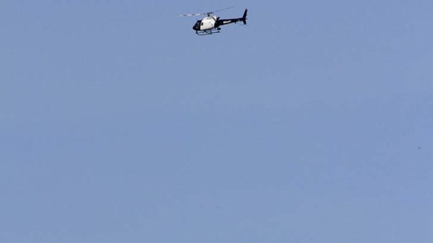 A Los Angeles Police helicopter searches an area near the Hollywood sign where dog walkers discovered an unidentified man's head.