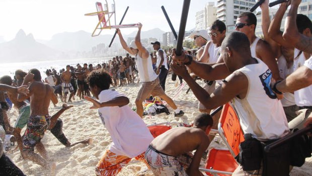 Mass robberies ... Municipal guards chase a gang of thieves that robbed bags and wallets from beachgoers on Arpoador beach in Rio de Janeiro on November 20.