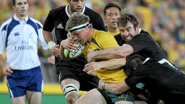 Michael Hooper is wrapped up by the All Blacks powerhouse in Sydney on Saturday night.