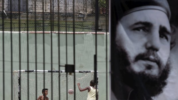 Children play soccer behind a picture of Cuba's former president Fidel Castro in Havana. 