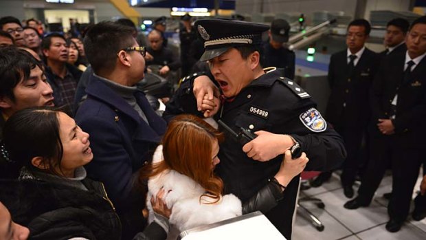 Stranded travellers argue with police and airport officials at Changshui International Airport.