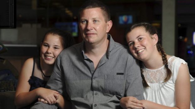 Recovering from his injuries, Andrew McInnes attends the fund raising benefit with daughters Taya, 12, left, and Courtney, 13.
