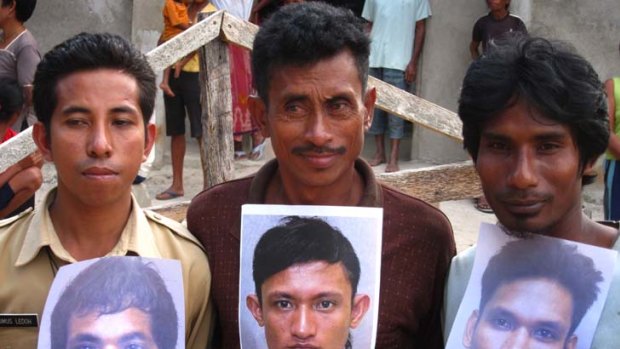 Relatives of three Indonesian boys, who were held in an adult prison in Brisbane until their recent release, holding photographs of their loved ones.