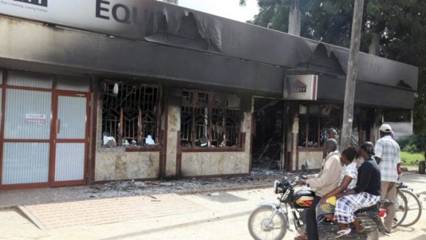 Residents of Mpeketoni view the damage left behind at the Equity bank.