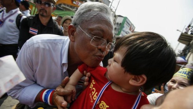Pucker up ... Anti-government protest leader Suthep Thaugsuban kisses a child as he marches during a rally in central Bangkok on Tuesday.
