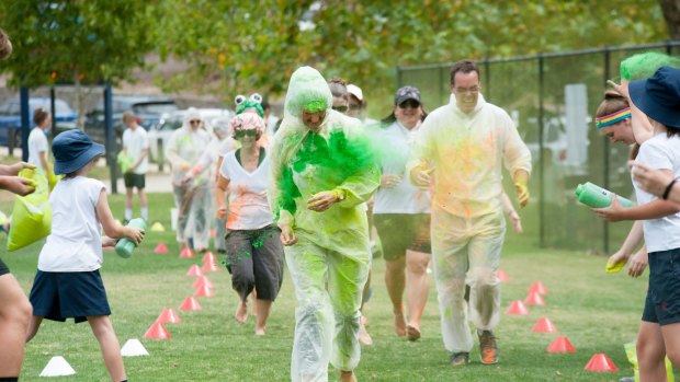Radford College principal Fiona Godfrey and head of junior school Paul Southwell get pelted in the school's own colour run on Thursday.