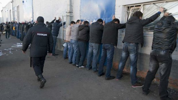 Russian police detain migrant workers during a raid at a vegetable warehouse in Moscow.
