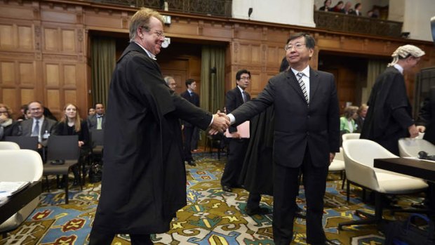 Japanese's Chief Negotiator Koji Tsuruoka, right, shakes hand with General Counsel of Australia Bill Campbell, left, before the International Court of Justice delivers its verdict in The Hague, Netherlands.