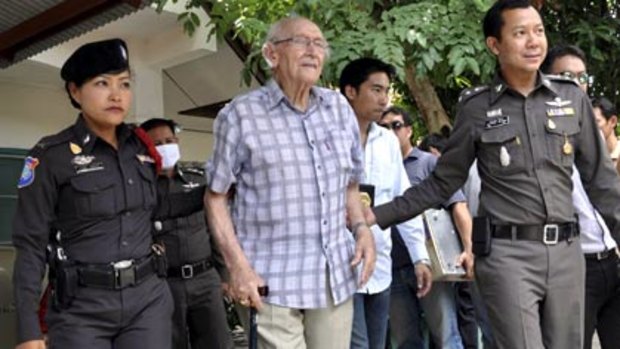 West Australian Karl Kraus, 90, is escorted by Thai police after his arrest.