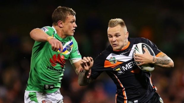 Blake Austin of the Tigers is tackled by Jack Wighton of the Raiders.